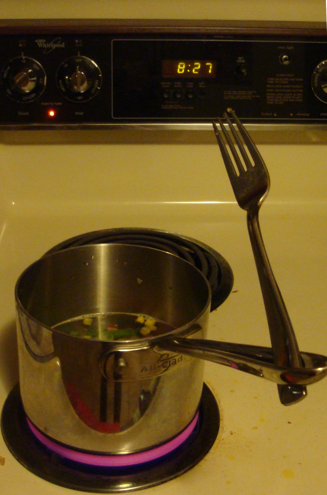 A pot of boiling water with a fork wedged into the handle.